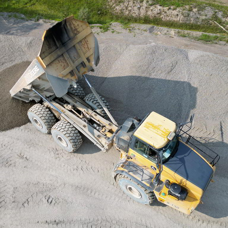 Articulated dump truck unloading gravel