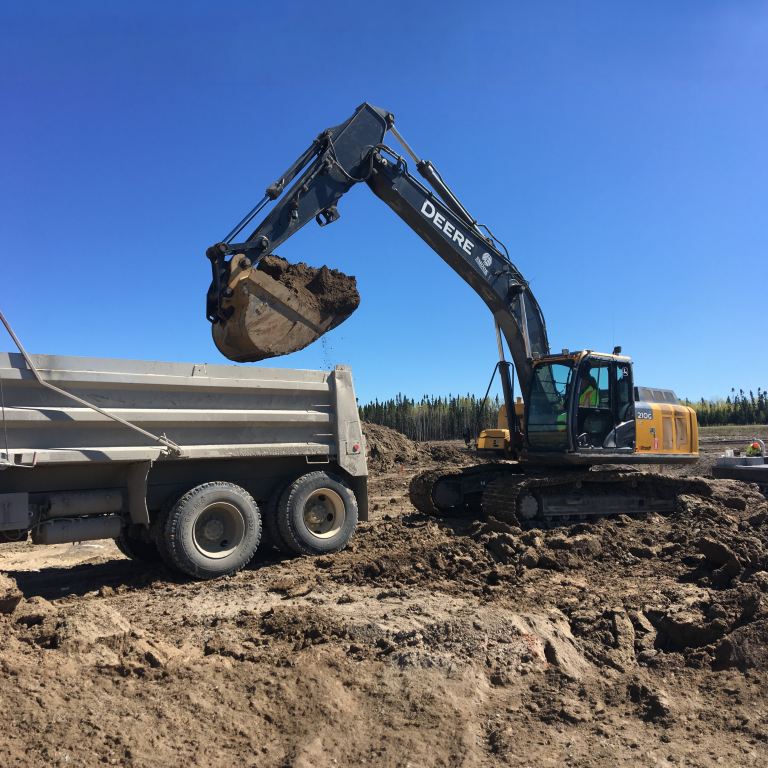 Excavator loading dirt into dump truck