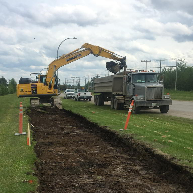 Excavator loading dump truck roadway