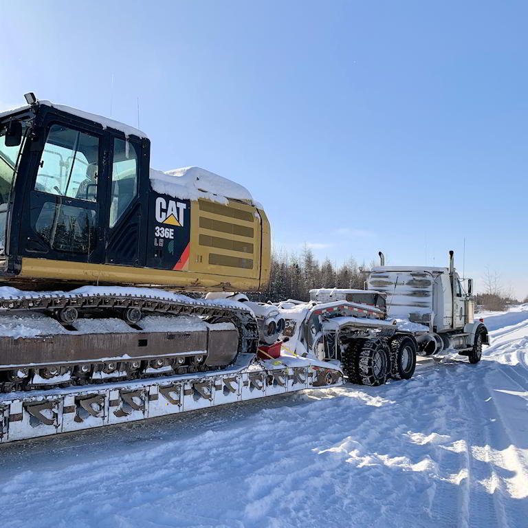 Hydraulic excavator and truck in snow